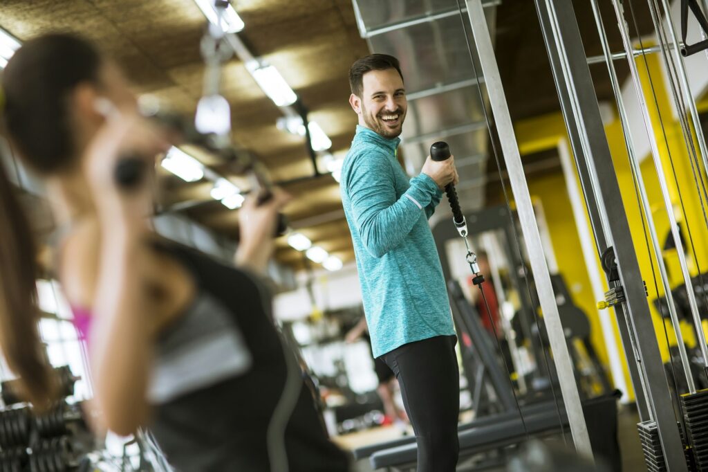 Young couple exercise bodybuilding exercises in the modern gym